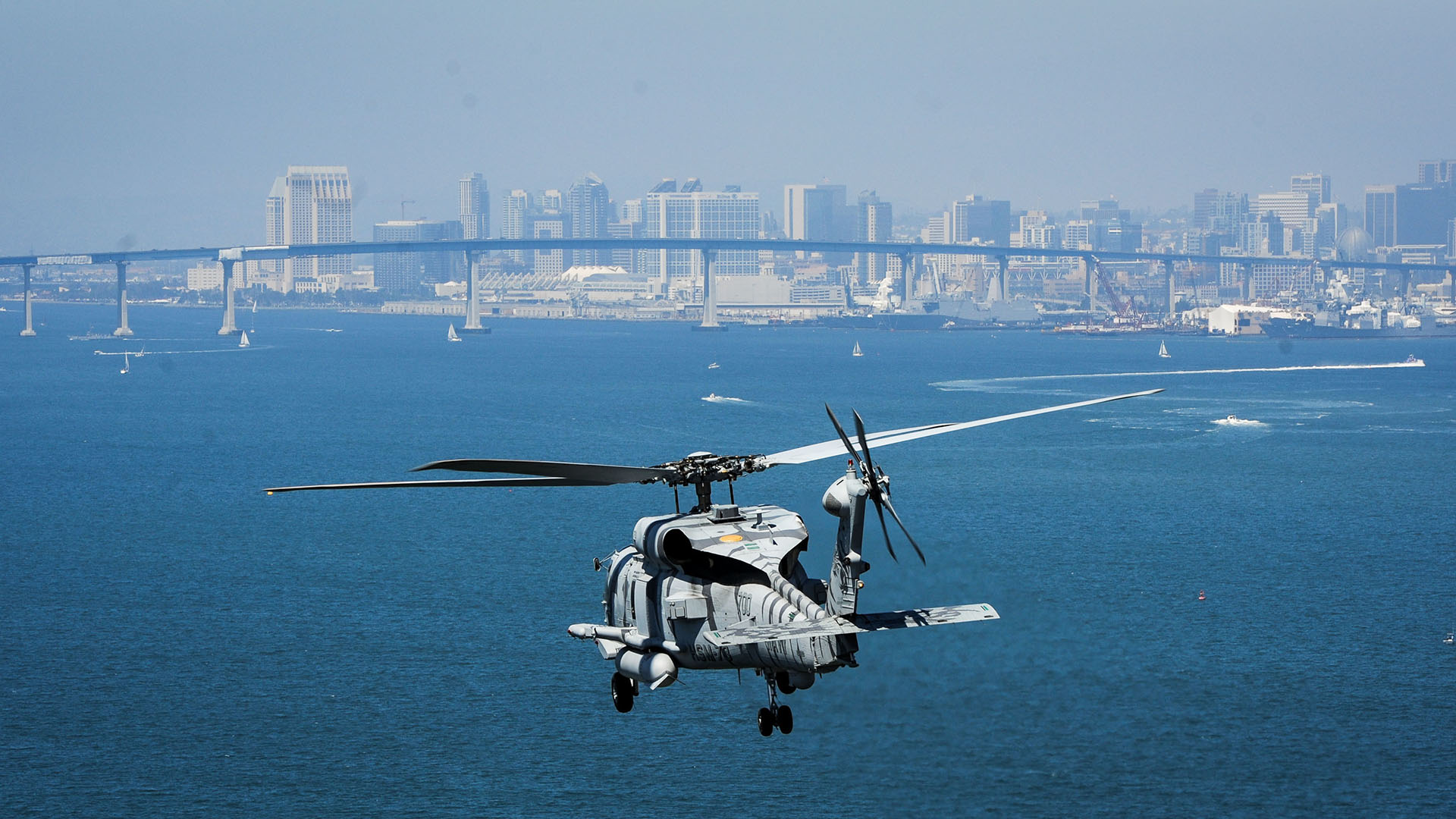 US Navy MH-60R Seahawk helicopter flies over San Diego City during daytime